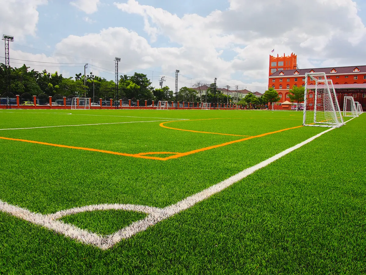 Lapangan sepak bola dengan permukaan rumput sintetis di sekolah internasional